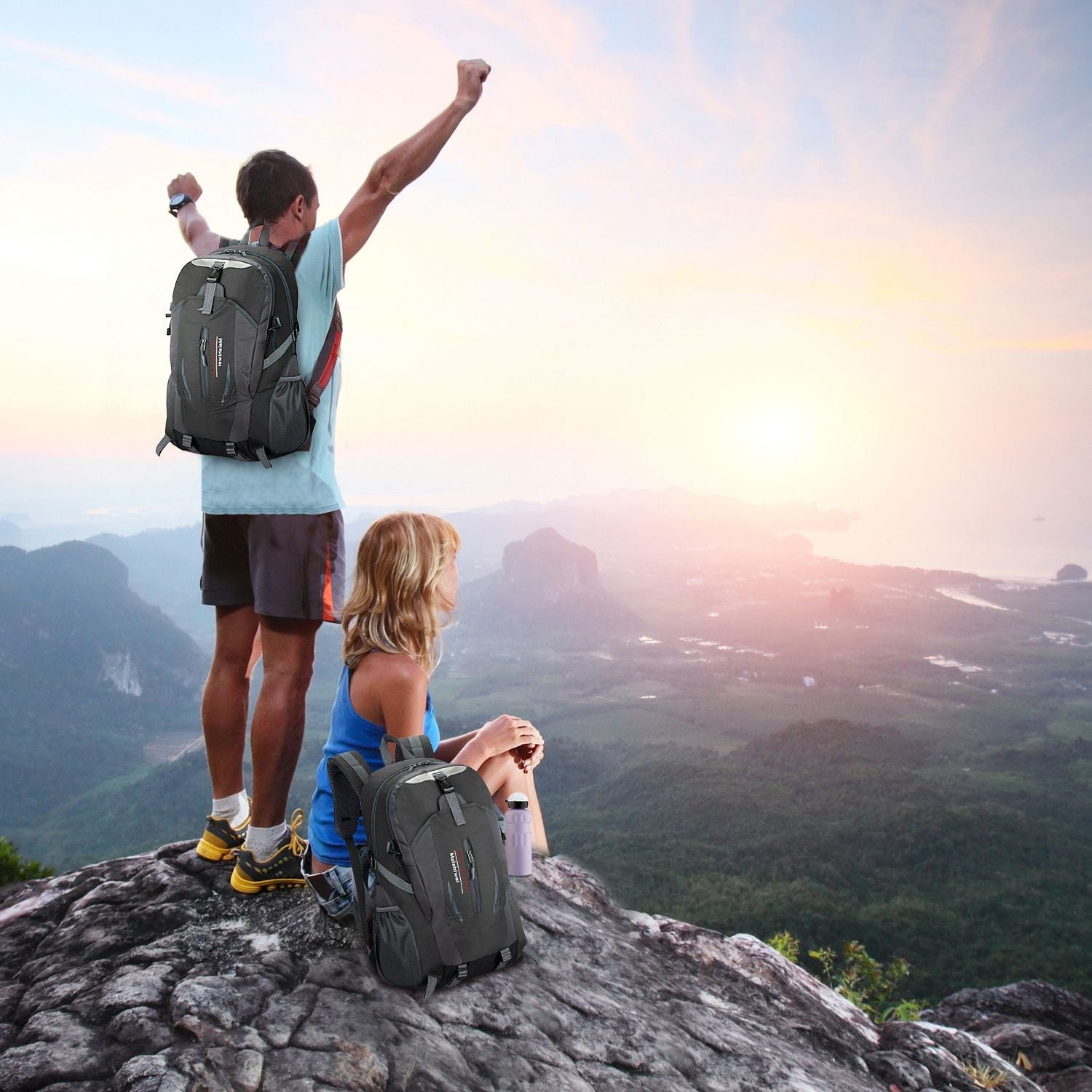 Visual of a couple camping to the peak of a mountain and standing triumphantly, observing the beauty of the scenery and sunset.
